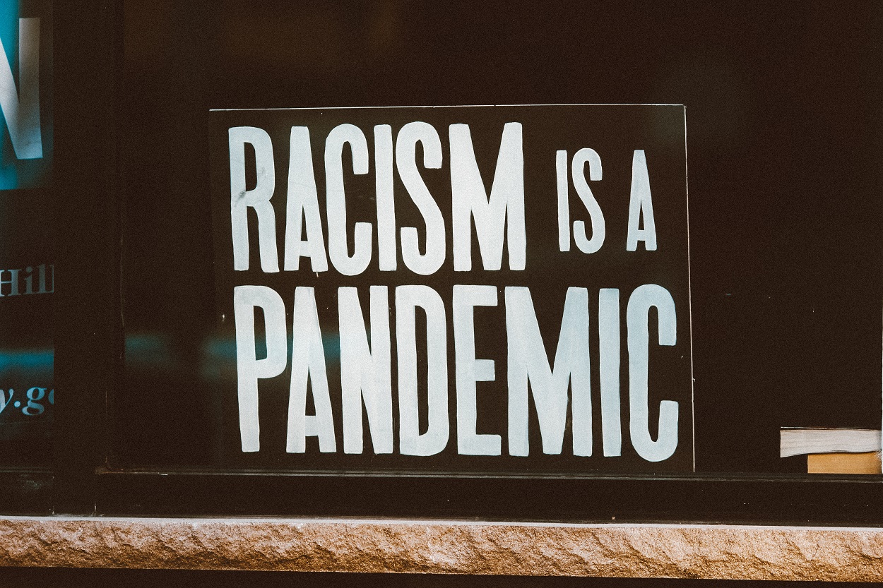Cartel que indica "el racismo es una pandemia". Jon Tyson