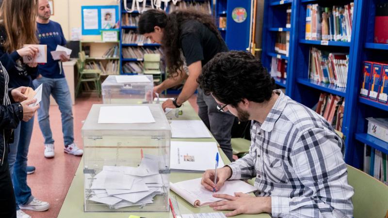 El presidente y un vocal de una mesa electoral apuntan los nombres de los votantes. EP