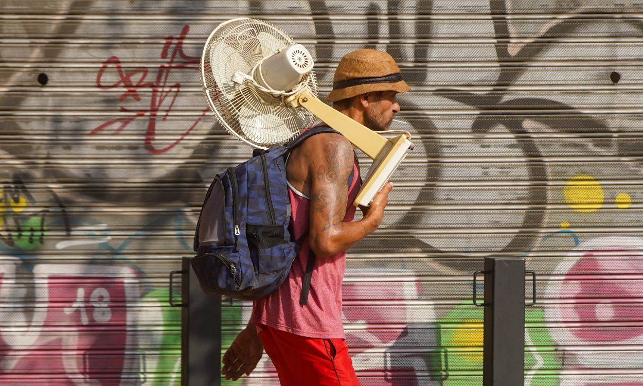 Un hombre con un ventilador por la calle en Sevilla con altas temperaturas. EP