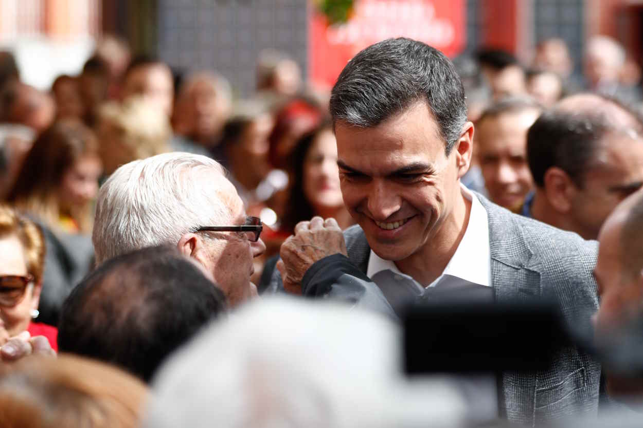 El presidente del Gobierno, Pedro Sánchez, saluda a un anciano a su llegada a un acto en el Centro Municipal de Mayores Juan Muñoz de Leganés (Madrid). EP