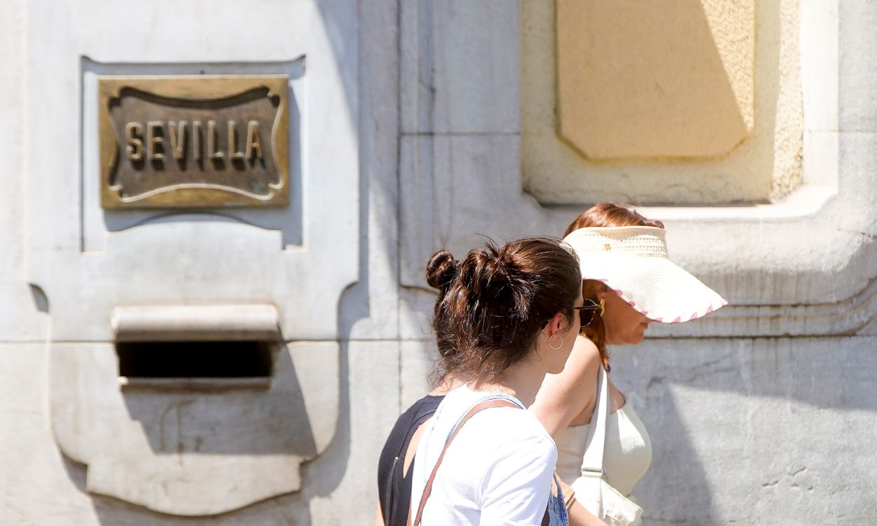 Unas turistas junto a la Catedral un día con aviso por altas temperaturas en Sevilla. EP