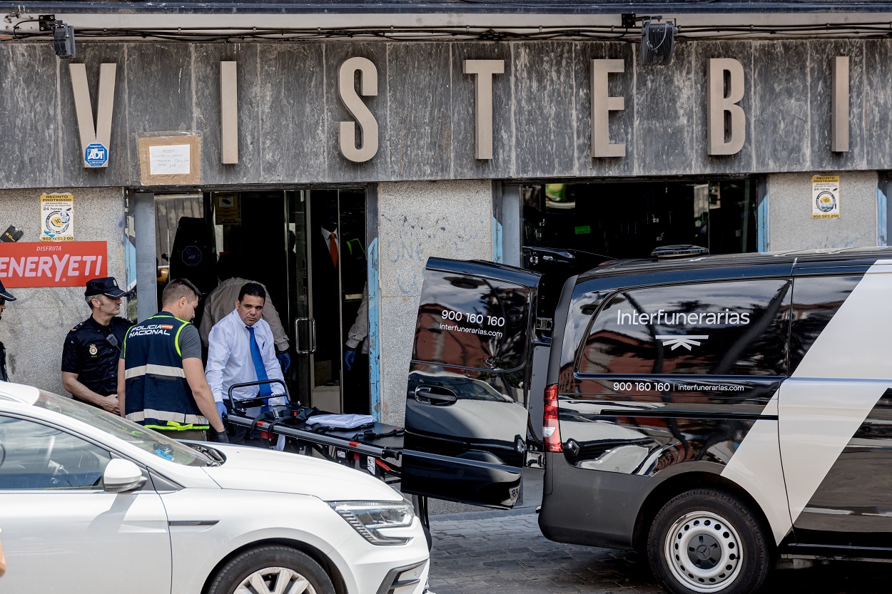 Un trabajador de Interfunerarias lleva la camilla para trasladar el cuerpo de la mujer apuñalada en la tienda de ropa de trabajo ‘Vistebien’, en la plaza de Tirso de Molina. EP.