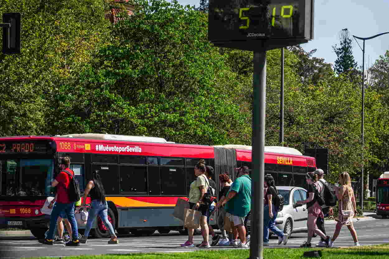 Un termómetro situado en el Prado, marca 51 grados al paso de transeúntes que resisten la fuerte ola de calor, a 26 de junio del 2023 en Sevilla. EP