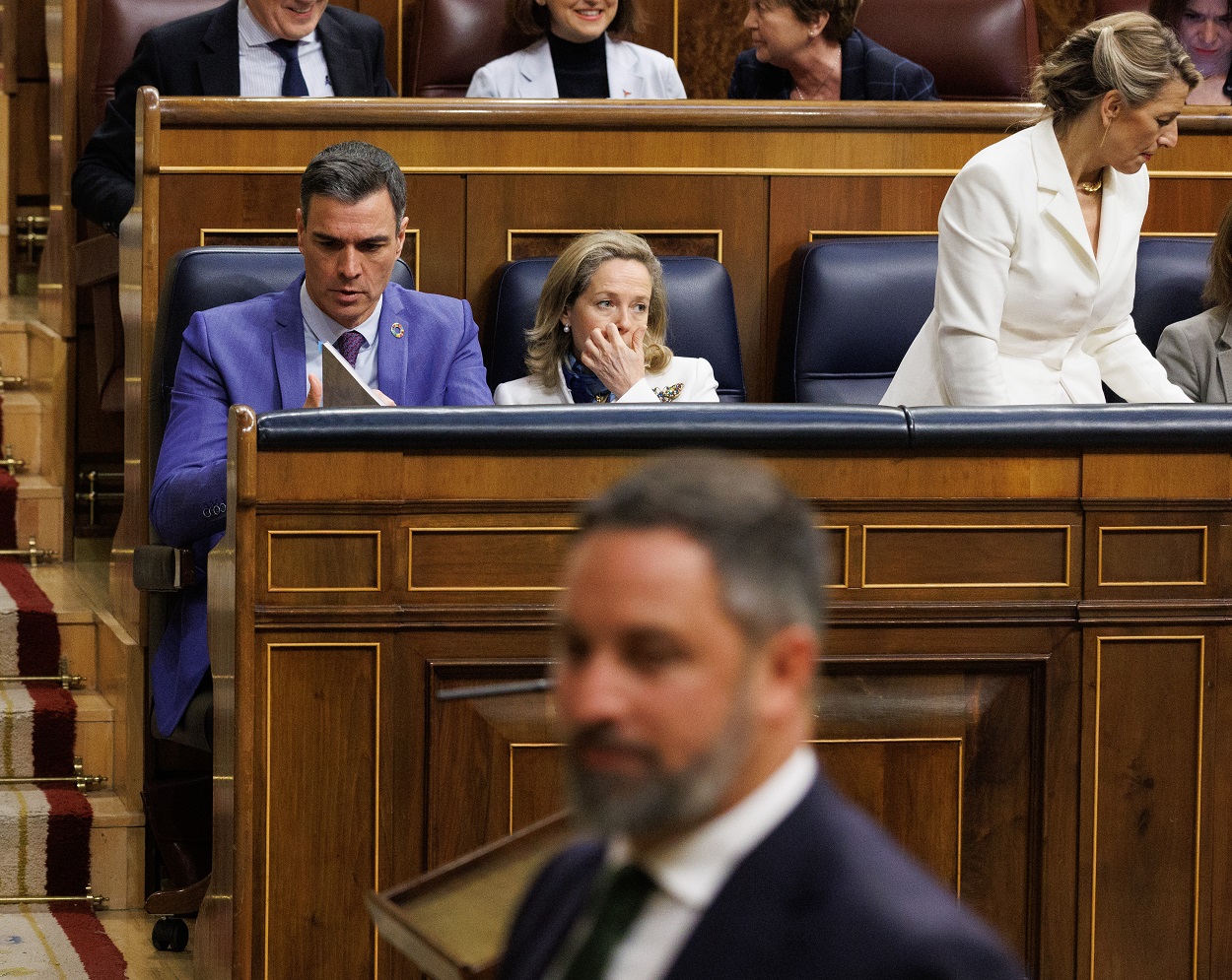 El presidente del Gobierno, Pedro Sánchez, junto a las vicepresidentas Nadia Calvió y Yolanda Díaz, mientras pasa el líder de Vox, Santiago Abascal. Eduardo Parra / Europa Press