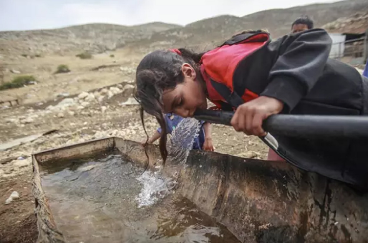 Una niña palestina bebiendo agua en Cisjordania. Archivo.