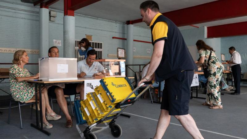 Un cartero llega al colegio electoral con el voto por correo correspondiente durante las elecciones generales.