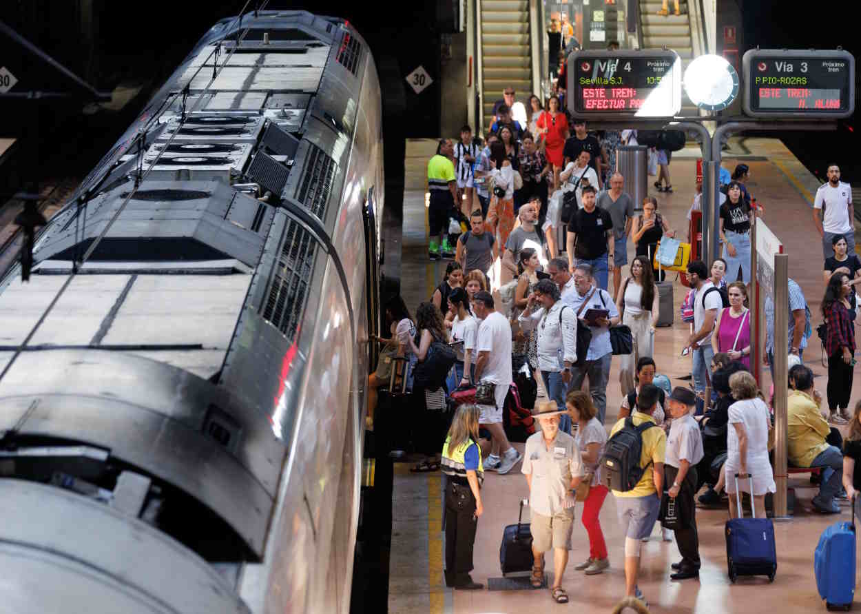 Varias personas con maletas en el andén de Renfe de la estación de Atocha Almudena Grandes. EP