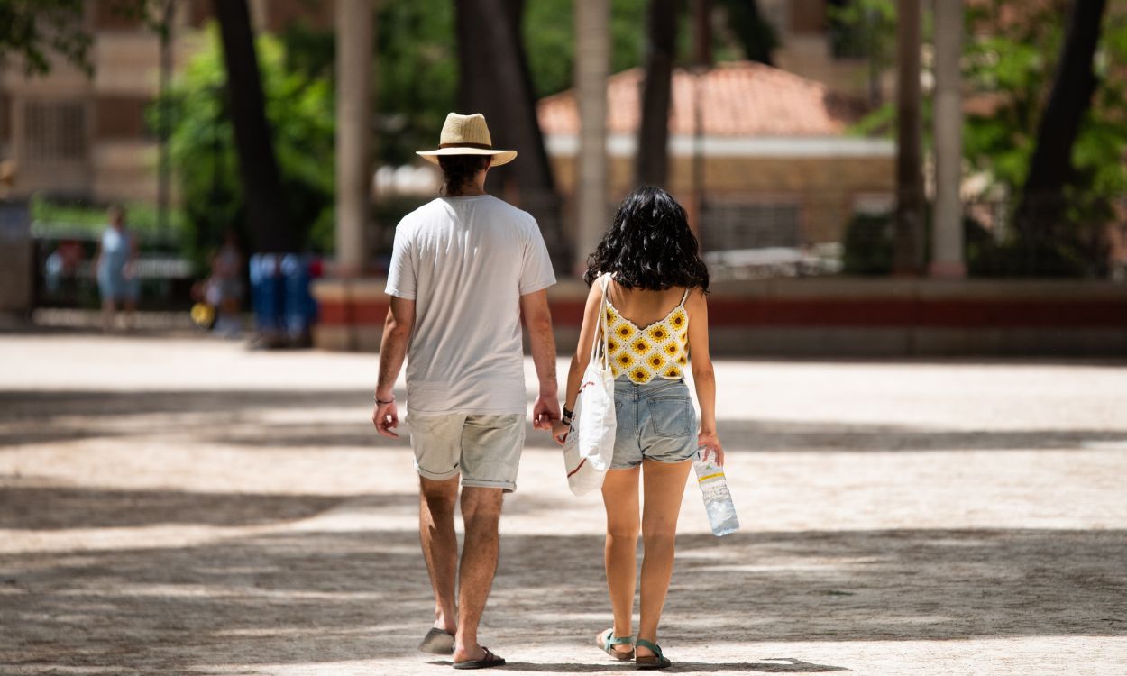 Una pareja camina con una botella de agua por el paseo principal del parque Abelardo Sánchez en Albacete, Castilla La Mancha. EP