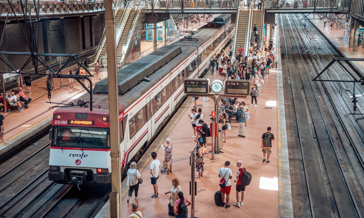 Varias personas en el andén de un tren de cercanías en la estación Almudena Grandes Atocha Cercanías de Madrid. EP