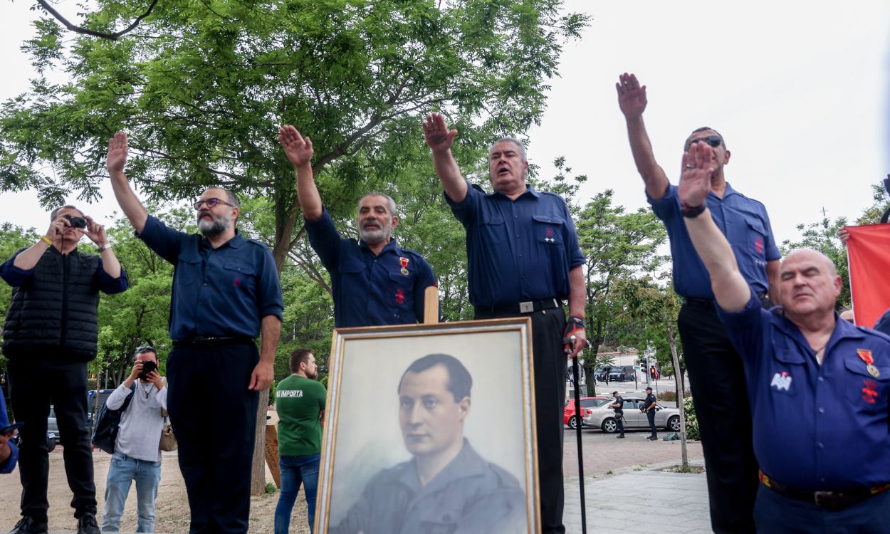 Varios falangistas junto a un retrato de Primo de Rivera durante el primer homenaje ante la nueva tumba de José Antonio Primo de Rivera, en el cementerio de San Isidro, a 29 de abril de 2023, en Madrid (España).