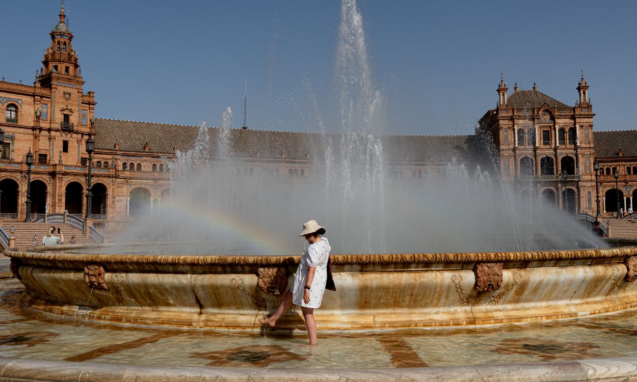 Una mujer se refresca del calor en Sevilla. EP.