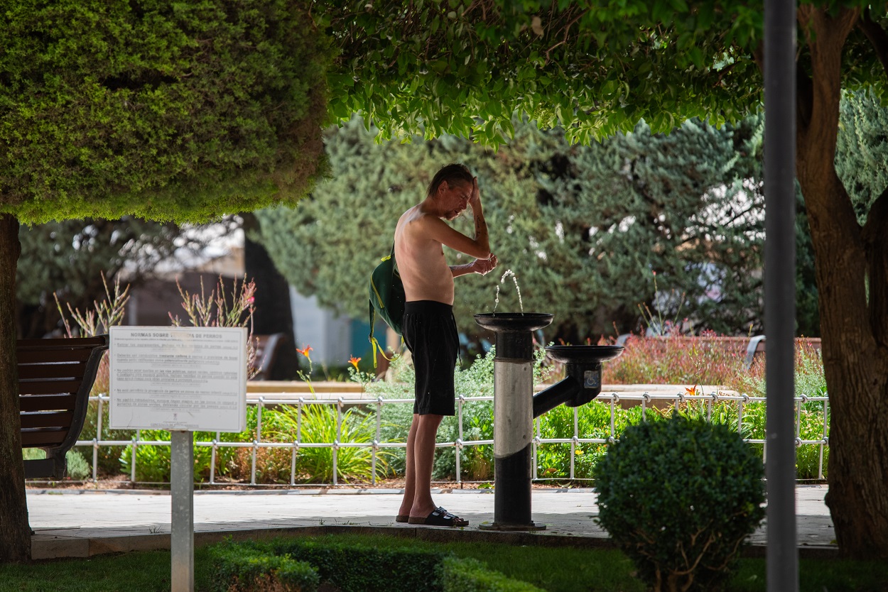 Un vecino se intenta refrescar en plena ola de calor. EP