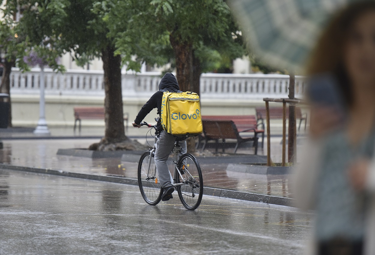 Un repartidor de Glovo durante una lluvia fuerte. EP