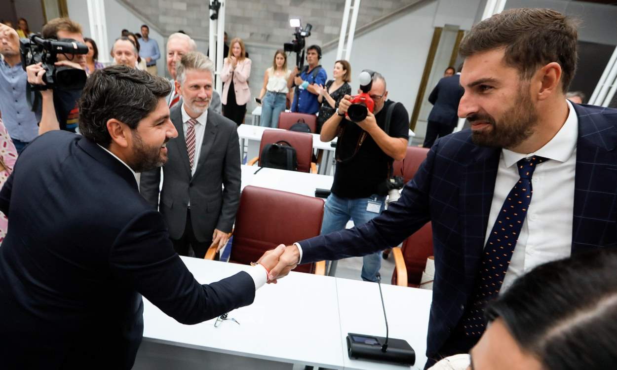 Fernando López Miras, líder del PP de Murcia, da la mano al presidente de Vox en la Región, José Ángel Antelo. EP