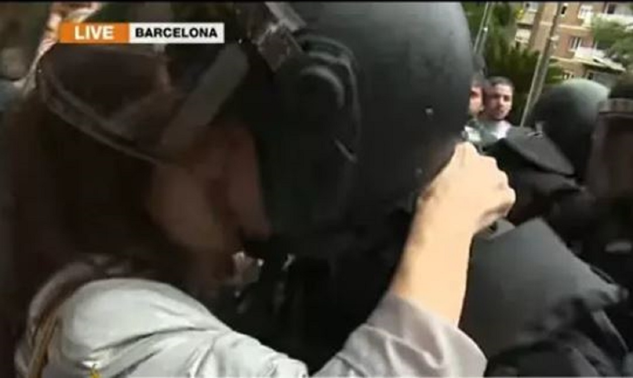 Captura del momento en el que una manifestante besa en la boca al agente. EP