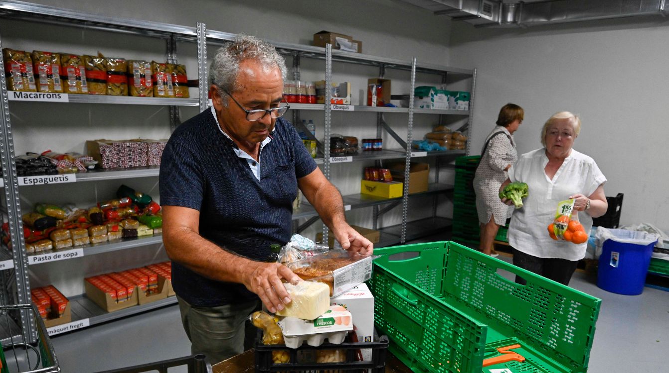 Ramón, voluntario de la entidad social De Veí a Veí, prepara una cesta de alimentos