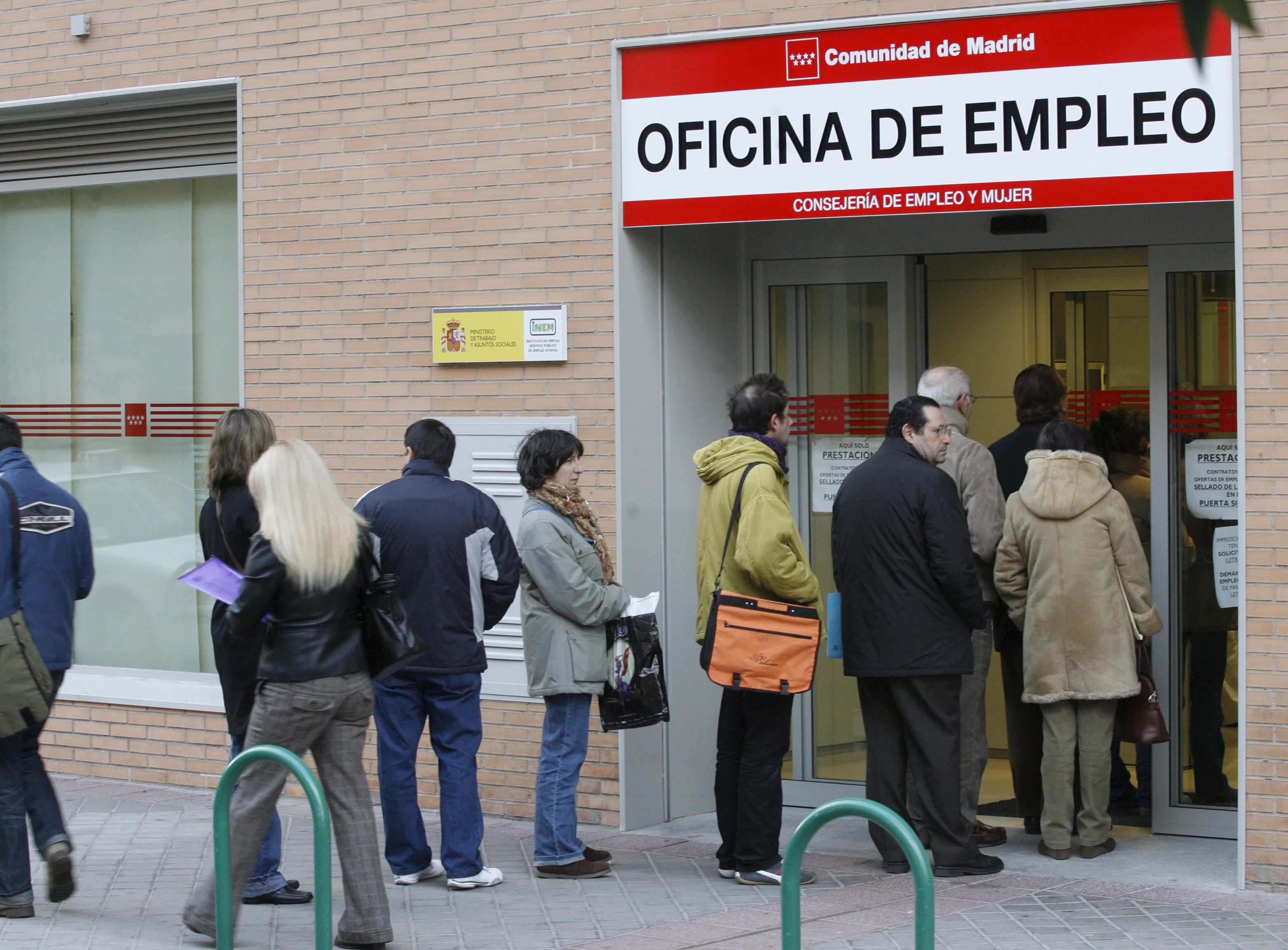 Un grupo de personas hacen cola en la entrada de una oficina de empleo de la Comunidad de Madrid