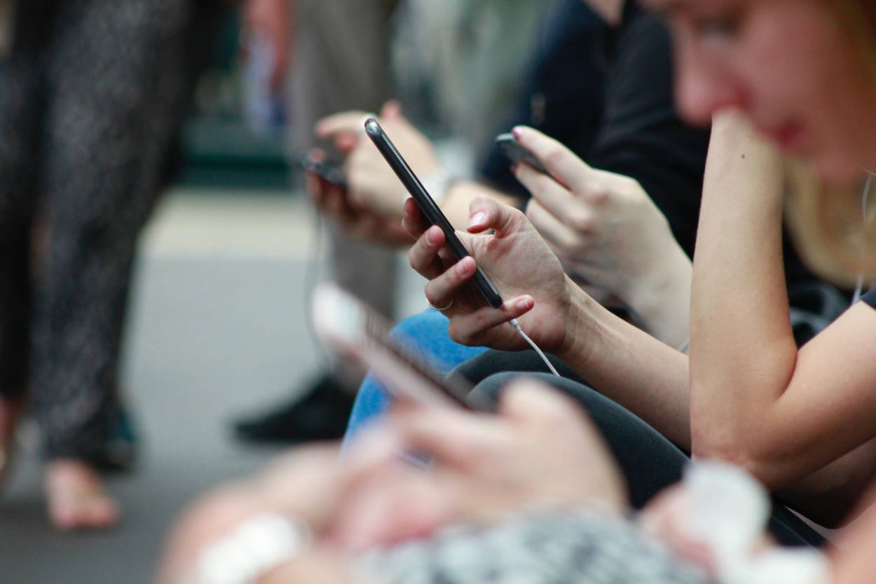 Una persona sostiene un teléfono móvil en sus manos. EP