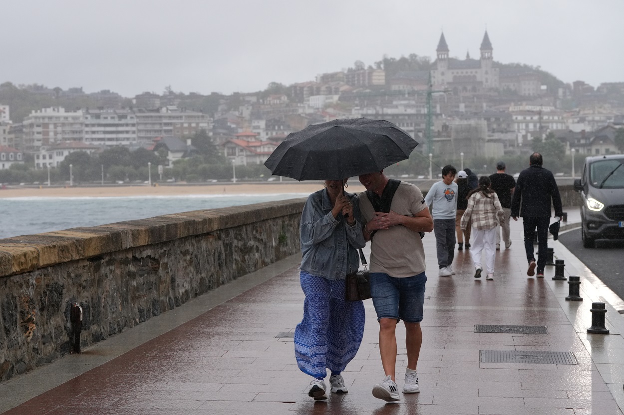 Imagen de personas caminando por un paseo marítimo. EP