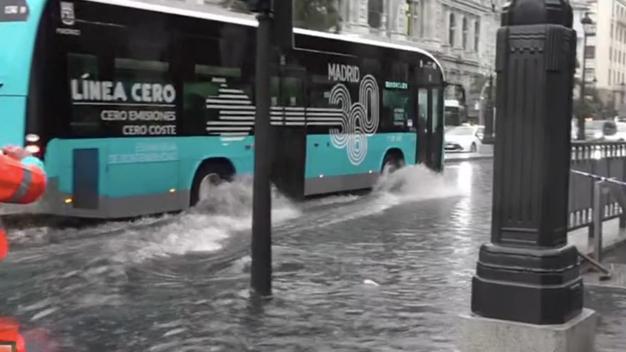 Un autobús, pasando por una zona inundada en Madrid.