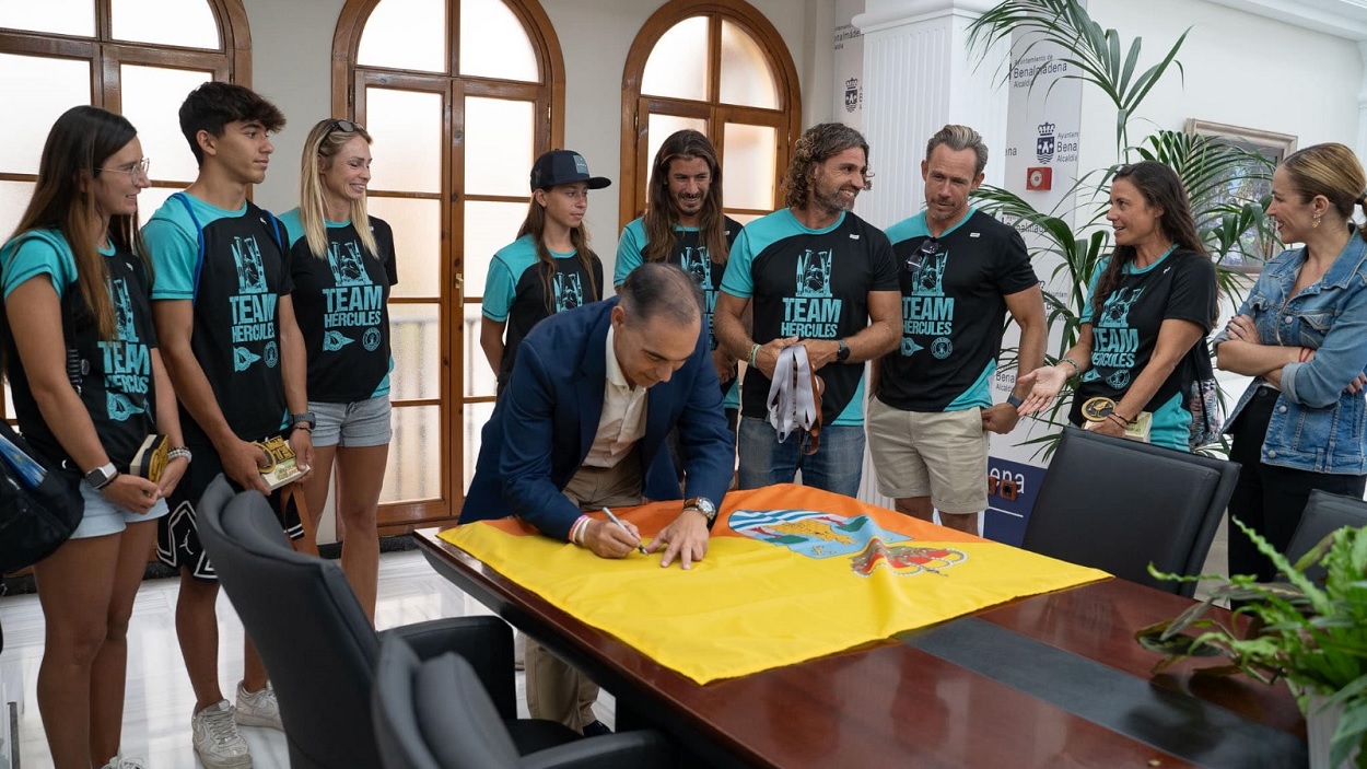 Juan Antonio Lara (PP) firmando una bandera de Benalmádena.