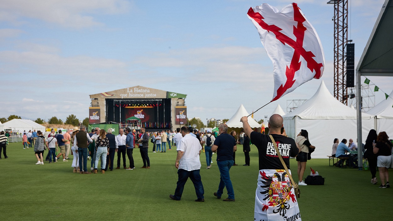 Un hombre con la bandera de la Cruz de Borgoña en el festival de Vox 'Viva 22'