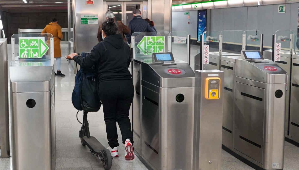 Una usuaria de Metro de Sevilla accede con un patinete eléctrico. EP