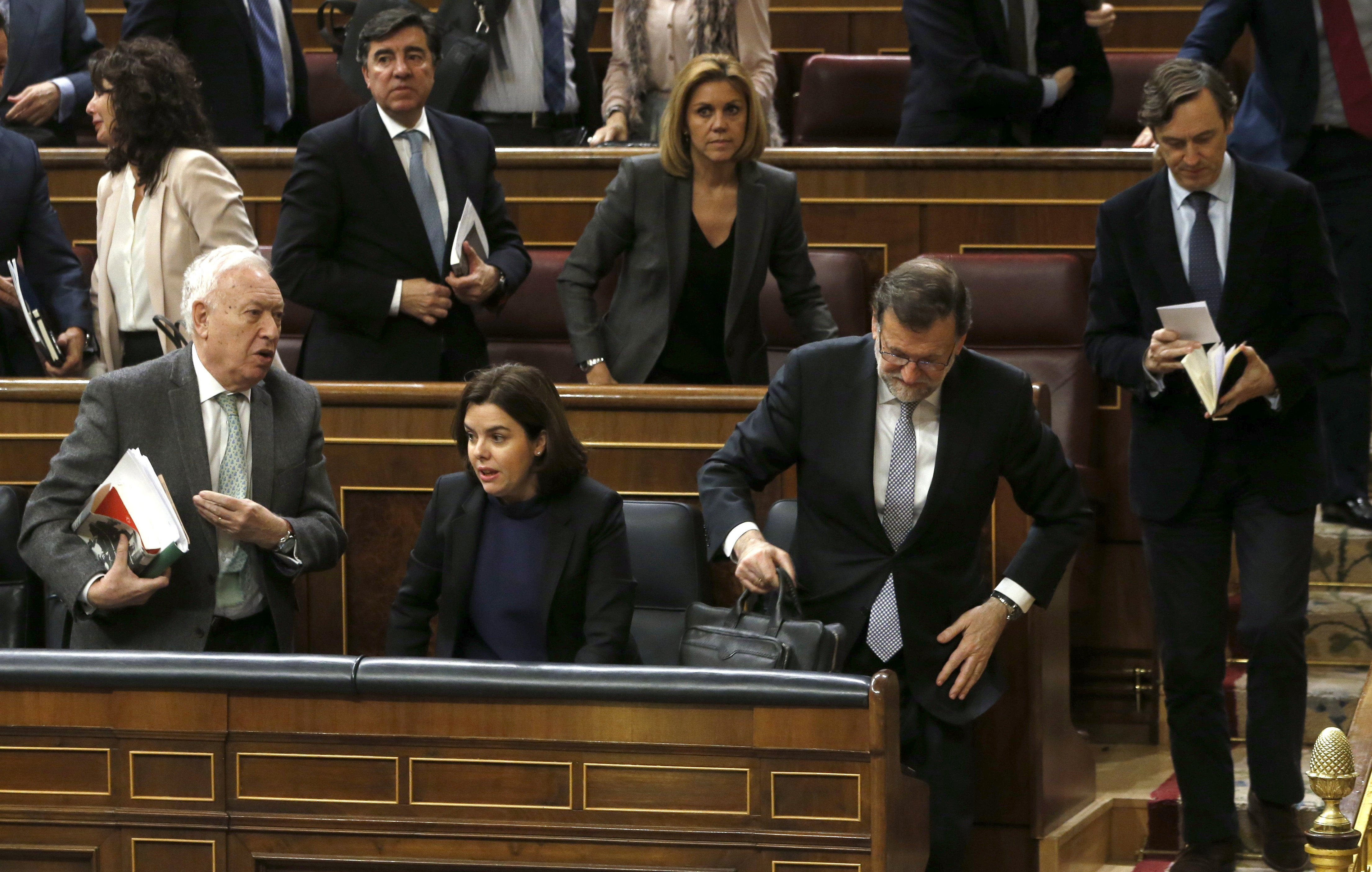 El presidente del Gobierno en funciones, Mariano Rajoy (d-primera fila), abandona el hemiciclo junto a sus compañeros de partido, al finalizar la sesión de la tarde de la segunda jornada del debate de investidura. 