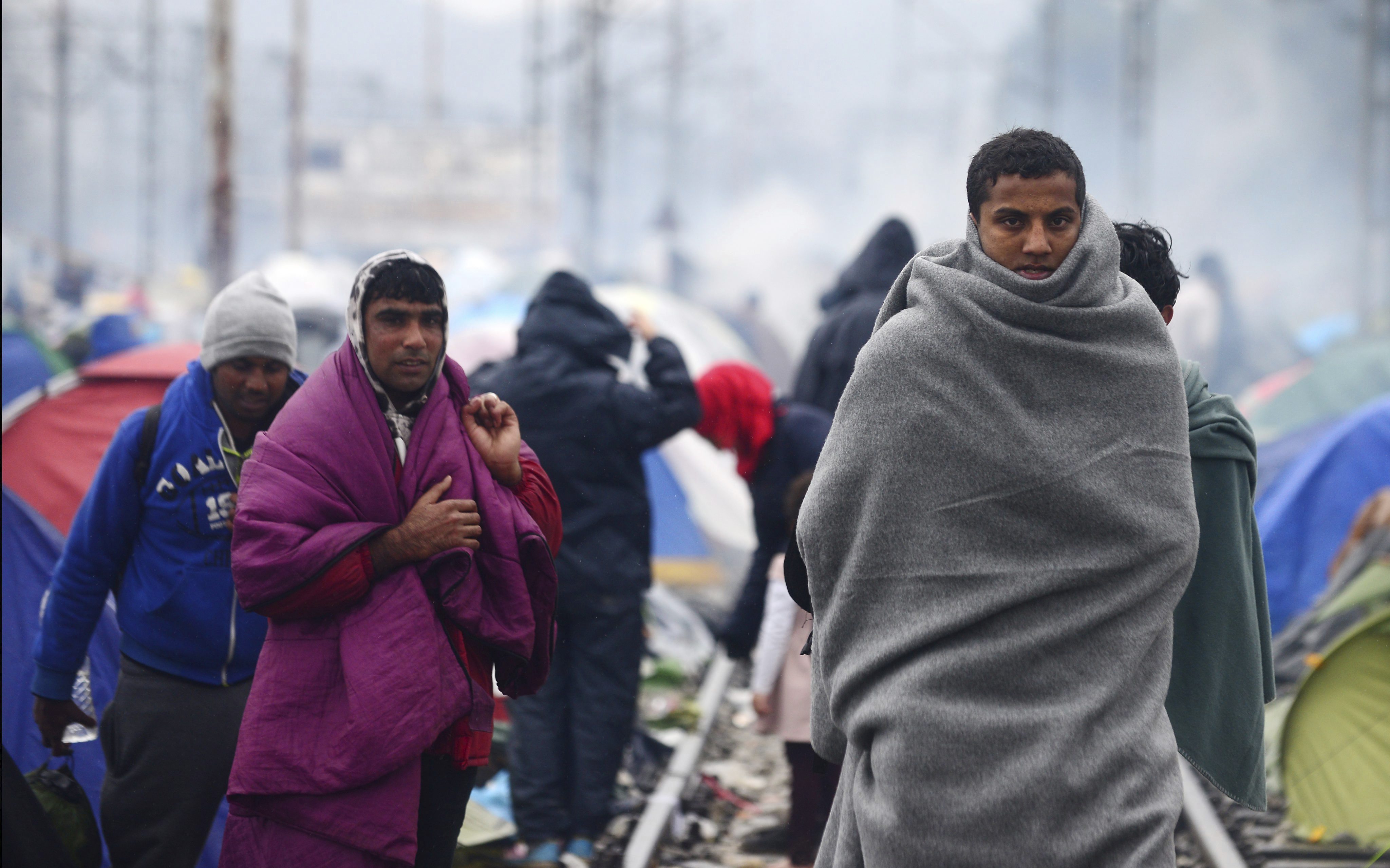 Migrantes vuelven al campamento de refugiados en la frontera entre Grecia y Macedonia, cerca de Idomeni (norte de Grecia), tras su intento por encontrar una vía alternativa para cruzar a Macedonia y ser detenidos por la policía.