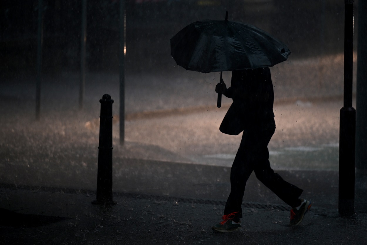 Una persona caminando bajo la lluvia, en una imagen de recurso. EP.