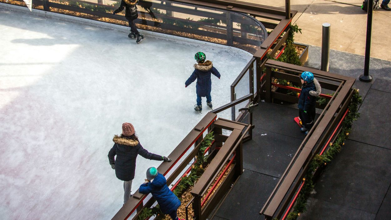 Niños jugando en una pista de patinaje sobre hielo. Unsplash.