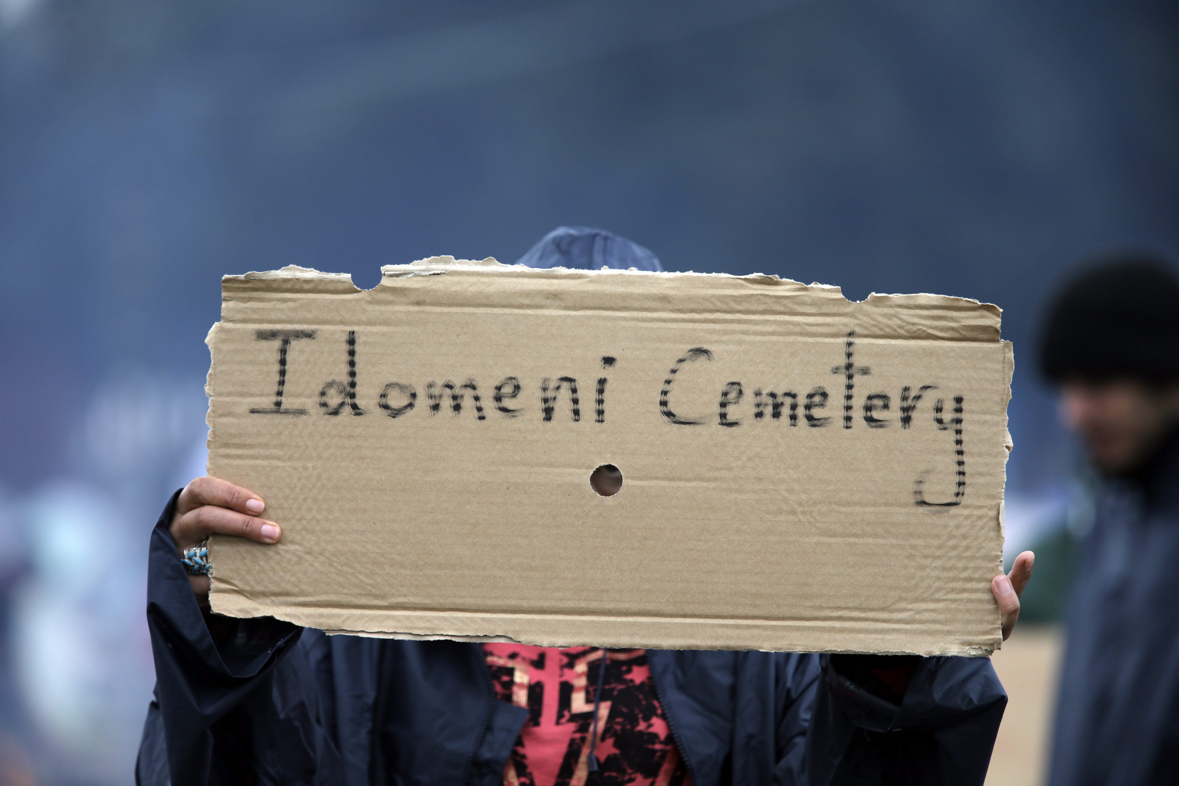 Un niño refugiado muestra un cartel en el que se lee "Cementerio de Idomeni", en el campo de refugiados de Idomeni, al norte de Grecia, el 23 de marzo del 2016.