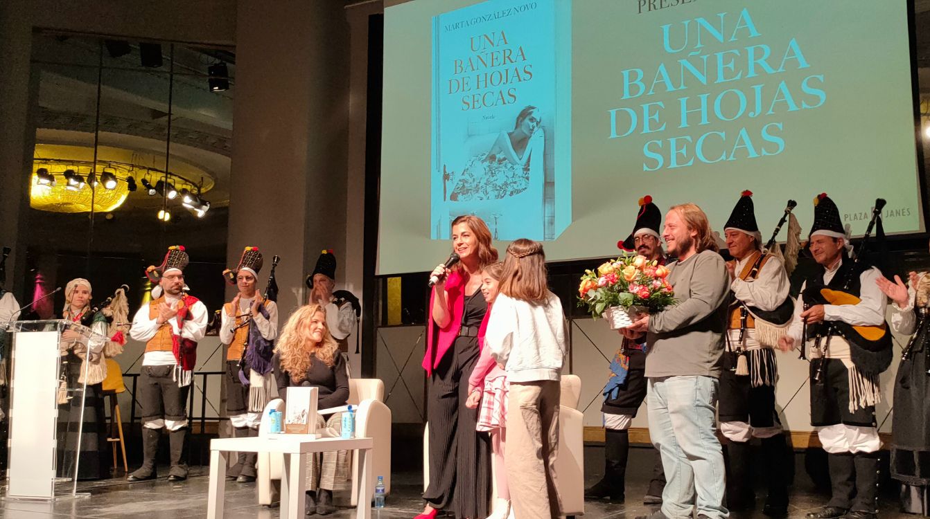 Un momento de la presentación del libro, con el grupo de gaiteros y las hijas de Marta González Novo entregándole un ramo de flores