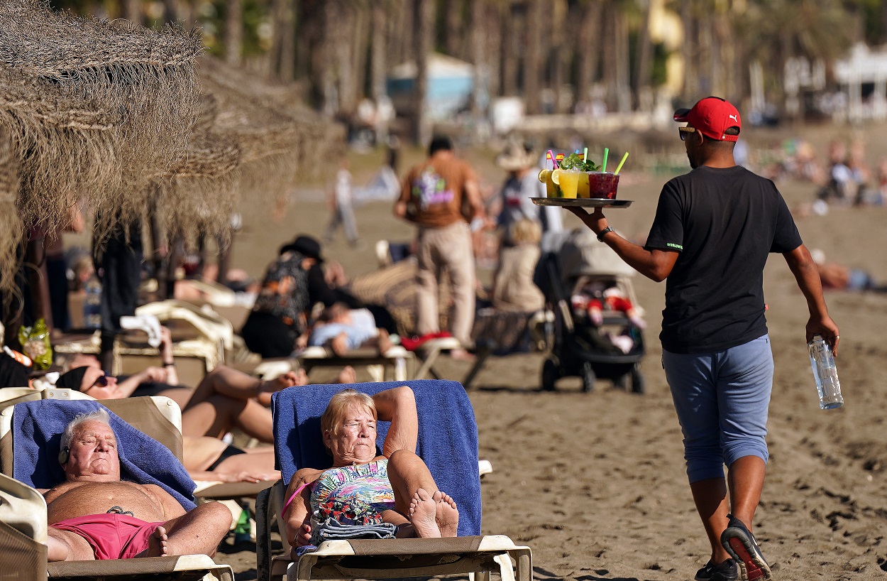 Varias personas disfrutan tomando el sol en la playa de la Malagueta en diciembre. EP.
