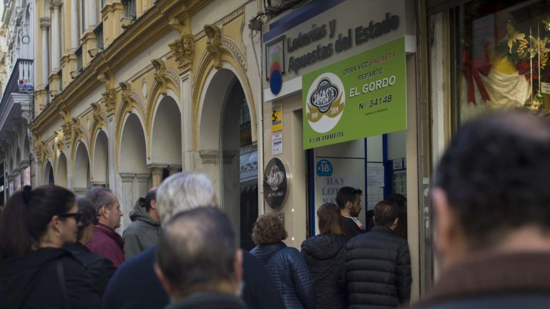 Largas colas para comprar lotería de Navidad en la administración de loterías de la calle Sagasta, en Sevilla