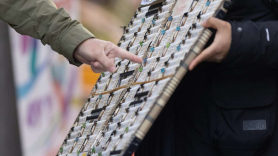 Una persona elige un décimo de la administración de lotería Doña Manolita de cara al Sorteo Extraordinario de la Lotería de Navidad