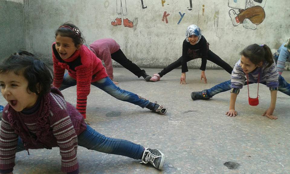 Unas niñas hacen gimnasia en el patio de un colegio sirio.