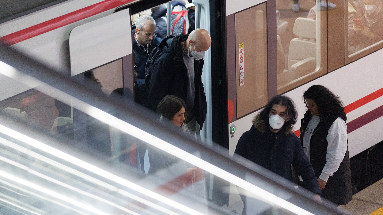 Varias personas con y sin mascarilla bajan de un vagón de un tren. EP. 