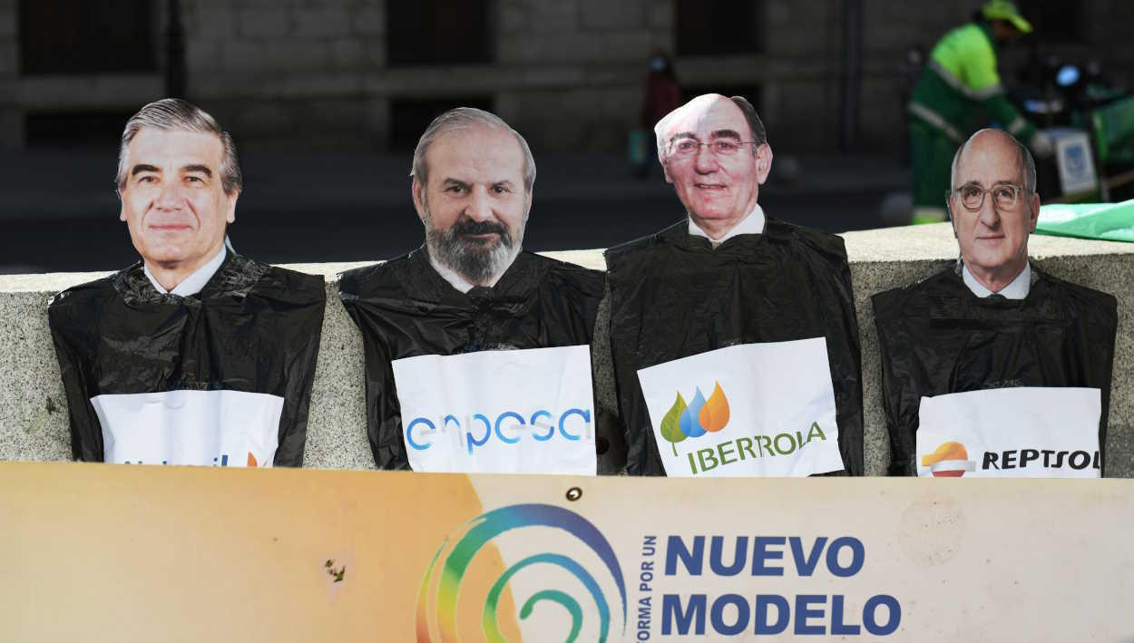 Retratos del presidente de Naturgy, el presidente de Endesa, el presidente de Iberdrola y el presidente de Repsol en una pancarta durante una manifestación. EP