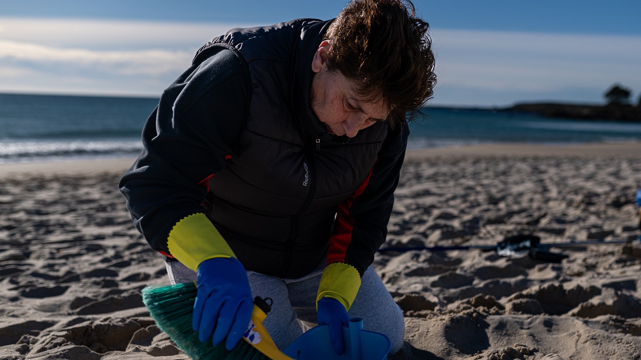 Una voluntaria recoge pellets en la playa
