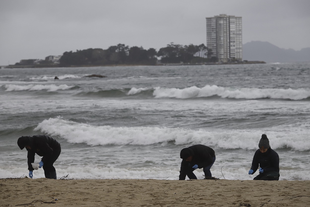 Voluntarios limpiando pellets este miércoles frente a la isla de Toralla, en Vigo (Foto: Europa Press).