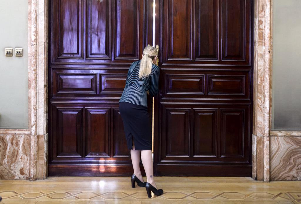 Cristina Cifuentes vigila por el resquicio de una puerta.