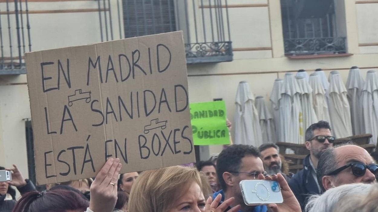 Una mujer portando un cartel en contra de la gestión sanitaria de la Comunidad de Madrid durante la manifestación de Navalcarnero. Redes.