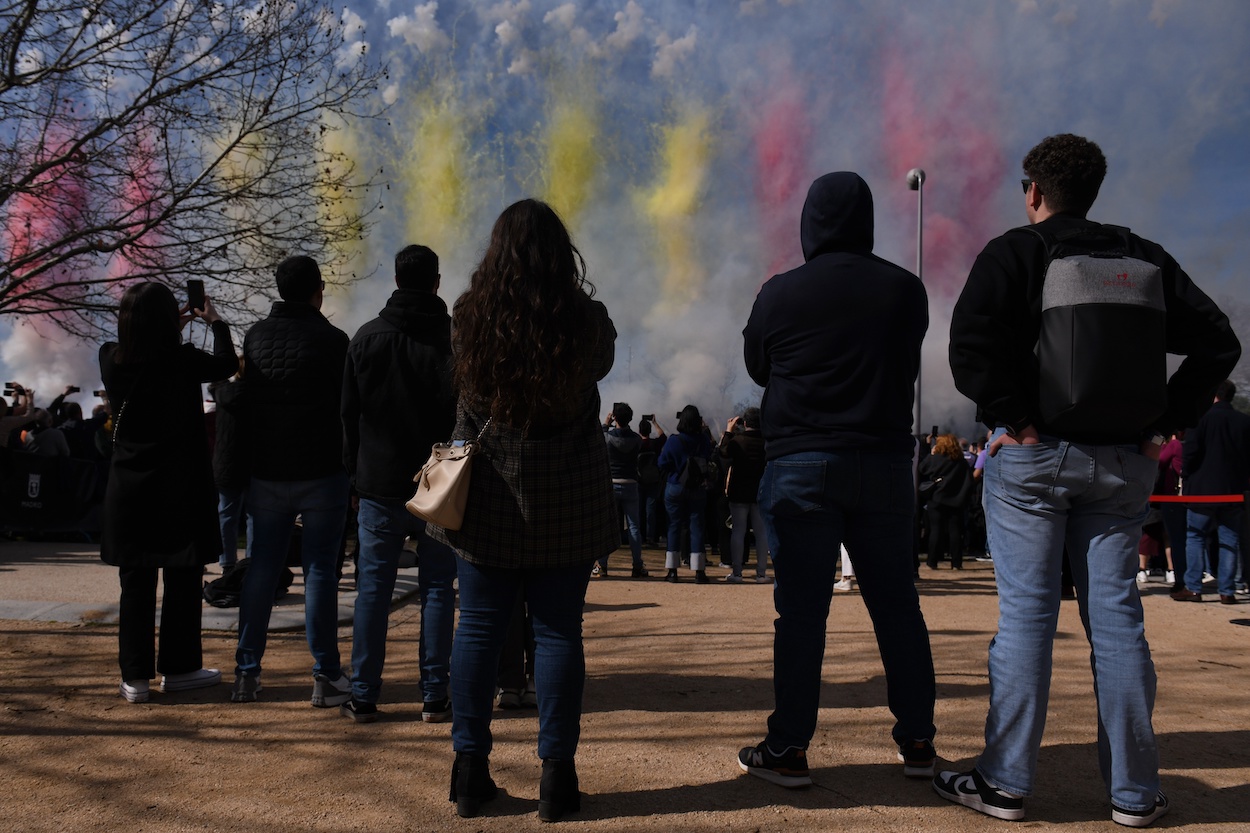 Varias personas observan el humo de colores durante la primera mascletà madrileña, en el Puente del Rey de Madrid Río, a 18 de febrero de 2024. EP