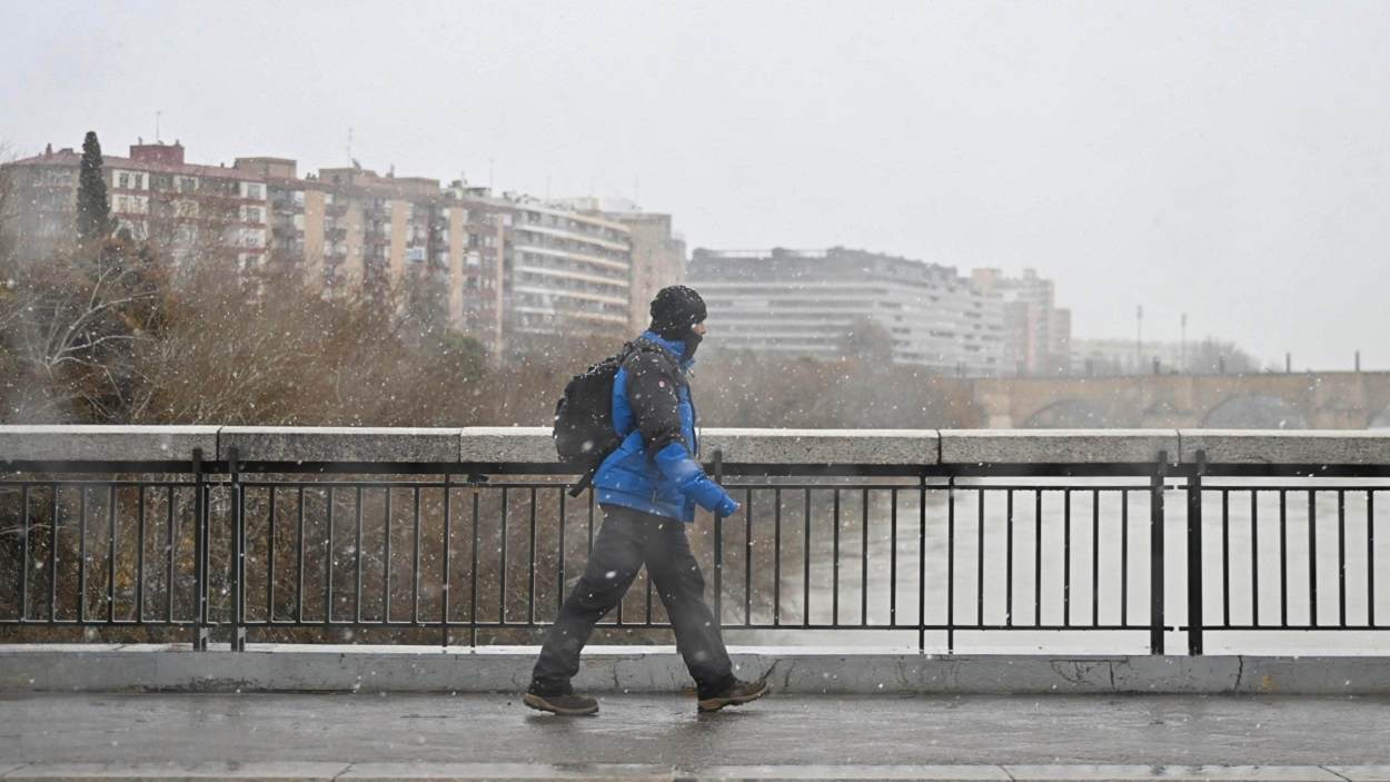 La Aemet alerta del regreso de la nieve. Una persona camina por Zaragoza. EP