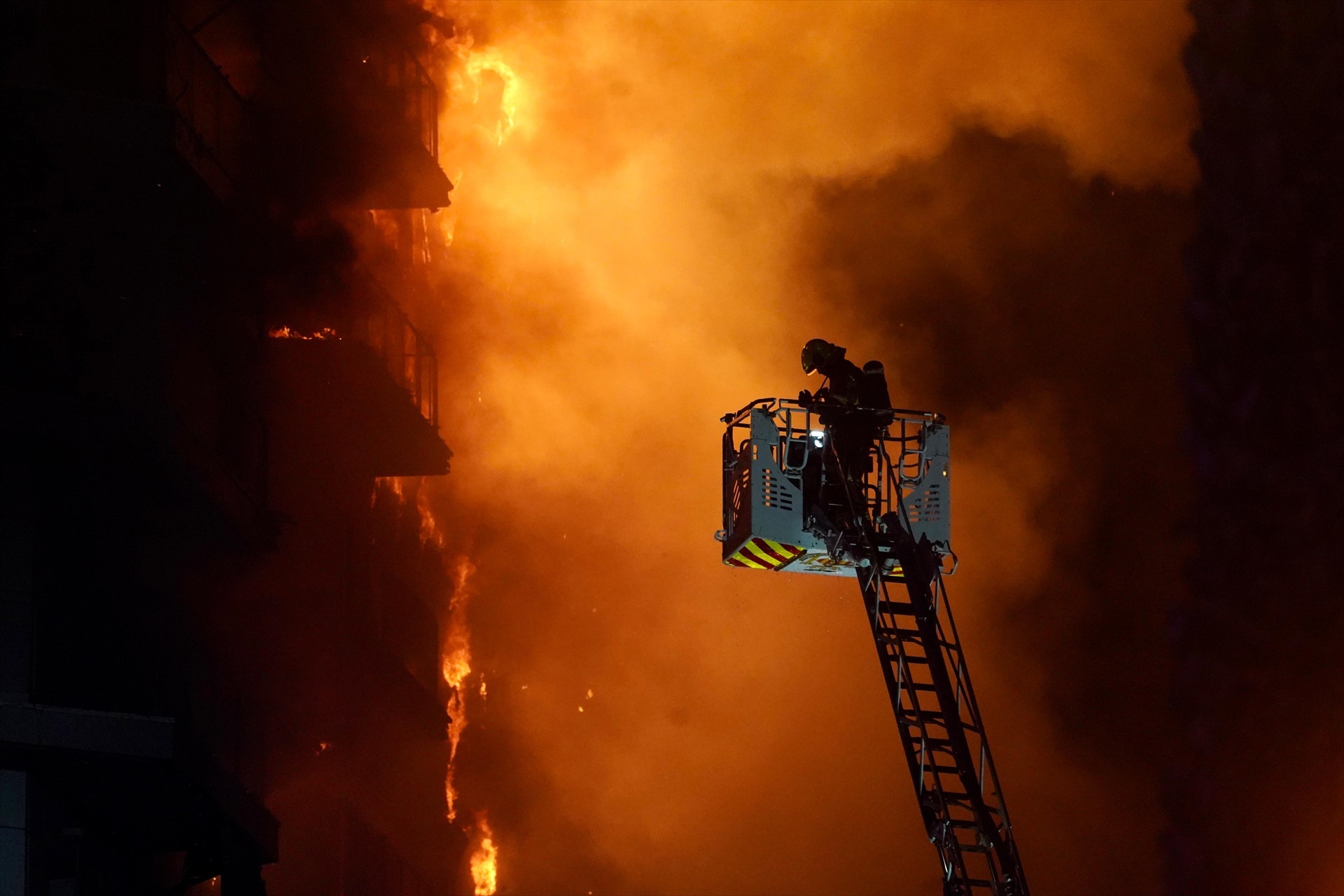 Un bombero trata de apagar el edificio en llamas, en el barrio de Campanar, a 22 de febrero de 2024, en Valencia, Comunidad Valenciana (España). 