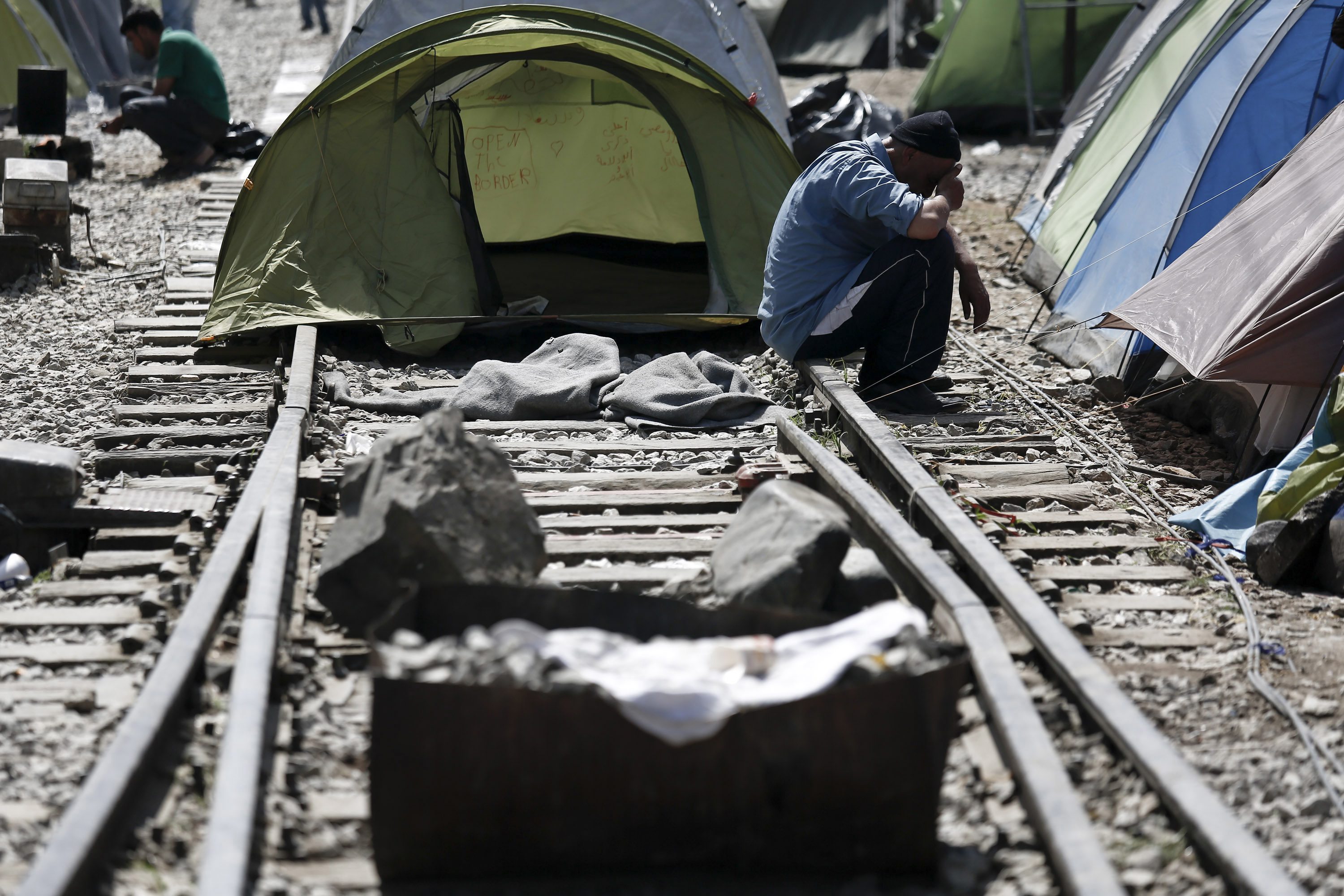 Un refugiado, sentado en las vías del tren bloqueadas con piedras, en el campo de Idomeni, en la frontera entre Grecia y Macedonia.