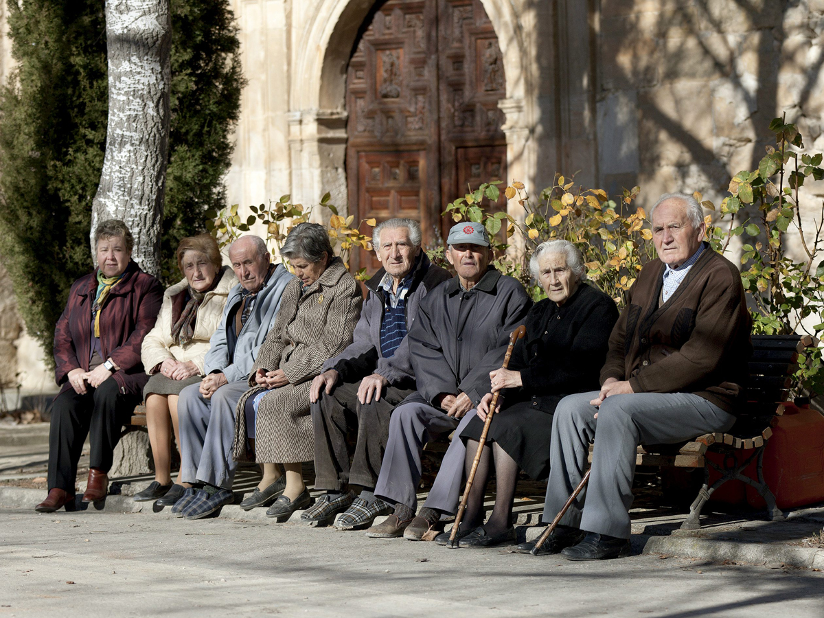 Varios ancianos sentados en un banco