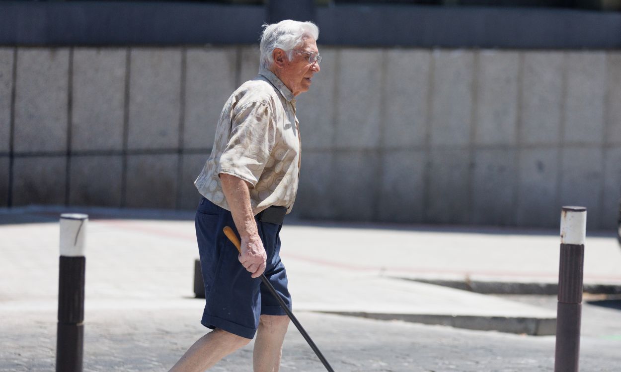 Un hombre mayor pasea con un bastón, a 24 de julio de 2023, en Madrid (España).