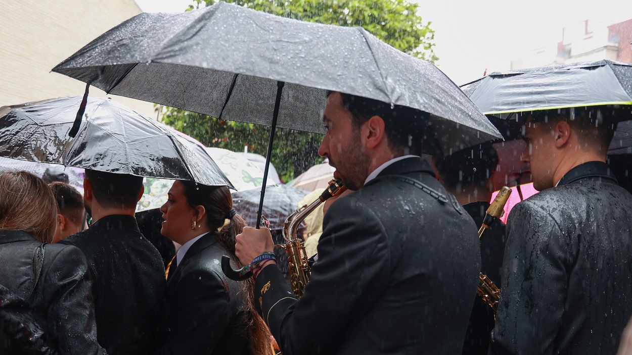 Músicos de la Hermandad del Cautivo de San Pablo se marchan tras suspenderse por la lluvia su estación de penitencia. EP